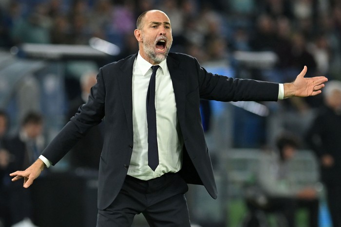 Igor Tudor, in a white shirt, black suit and tie, holds both arms wide as he shouts on the pitch at Allianz Stadium.