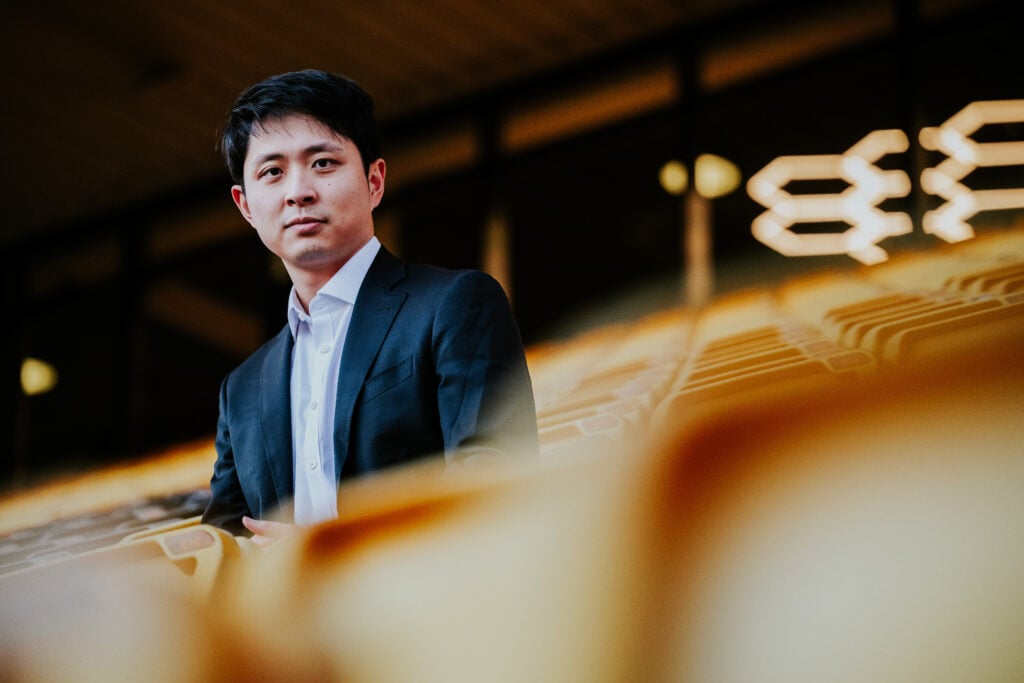 Nathan Shi sitting down at Molineux.