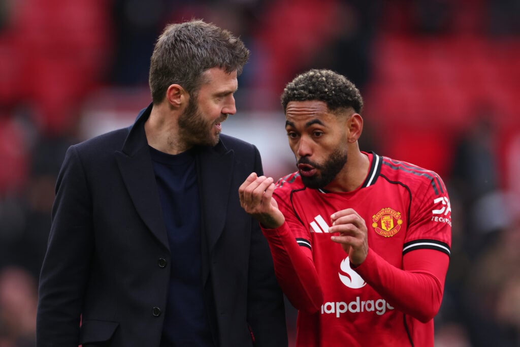 Michael Carrick speaks with Matheus Cunha during the Premier League match between Manchester United and Aston Villa at Old Trafford in 2026 in Manchester, England.