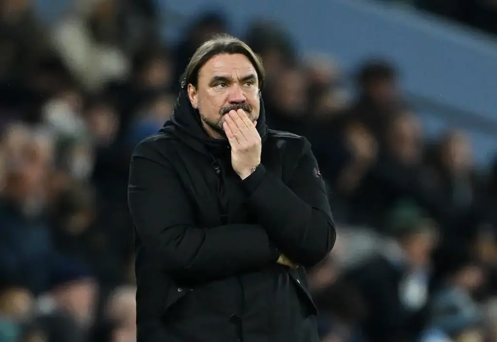 Leeds United boss Daniel Farke holds his hand to his face as he strikes a thoughtful look on the touchline of a game