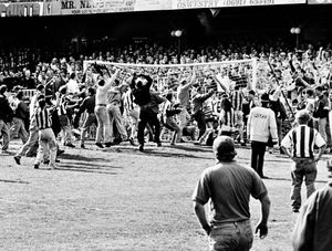 Goalmouth scramble... Police can only watch helplessly as Baggies fans take out their frustration.