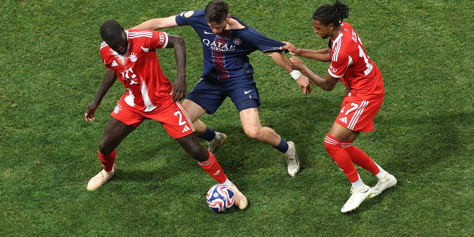  Bayern Munich's Dayot Upamecano and Michael Olise in action with Paris St Germain's Khvicha Kvaratskhelia