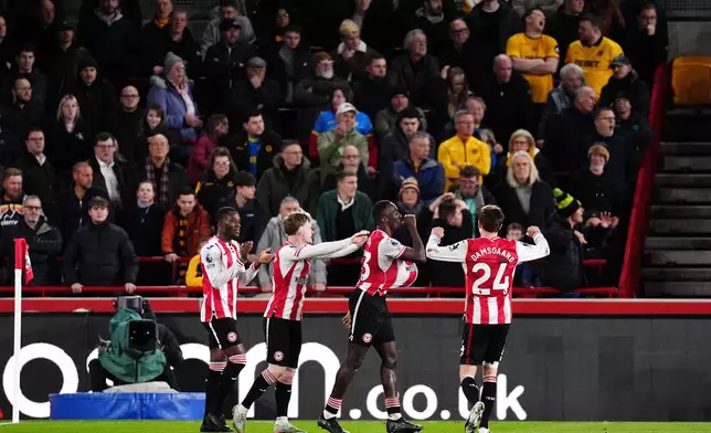 Brentford's Michael Kayode, second right, celebrates scoring with teammates during the English Premier League soccer match between Brentford and Wolverhampton Wanderers in London, Monday March 16, 2026. (John Walton/PA via AP)