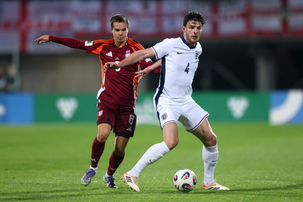 RIGA, LATVIA - OCTOBER 14: Declan Rice of England battles for possession with Renars Varslavans of Latvia during the FIFA World Cup 2026 qualifier match between Latvia and England at Daugava Stadium on October 14, 2025 in Riga, Latvia. (Photo by Carl Recine/Getty Images)