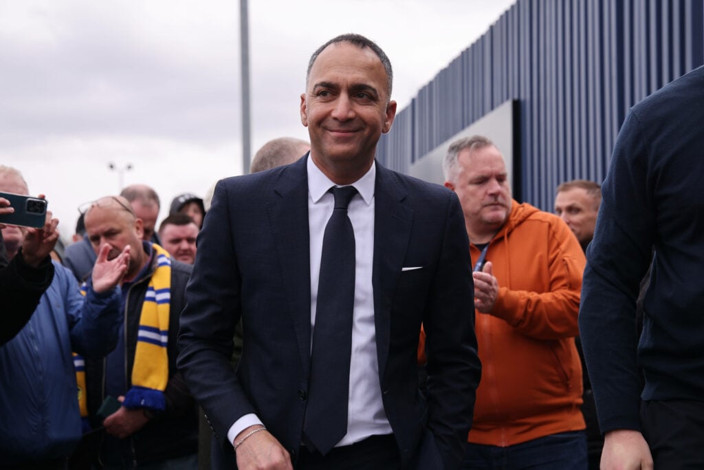 Paraag Marathe walks through a crowd at Leeds United