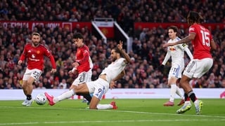 Dominic Calvert-Lewin of Leeds United has a shot while under pressure from Lisandro Martinez of Manchester United during the Premier League match between Manchester United and Leeds United at Old Trafford on April 13, 2026 in Manchester, England. (Photo b