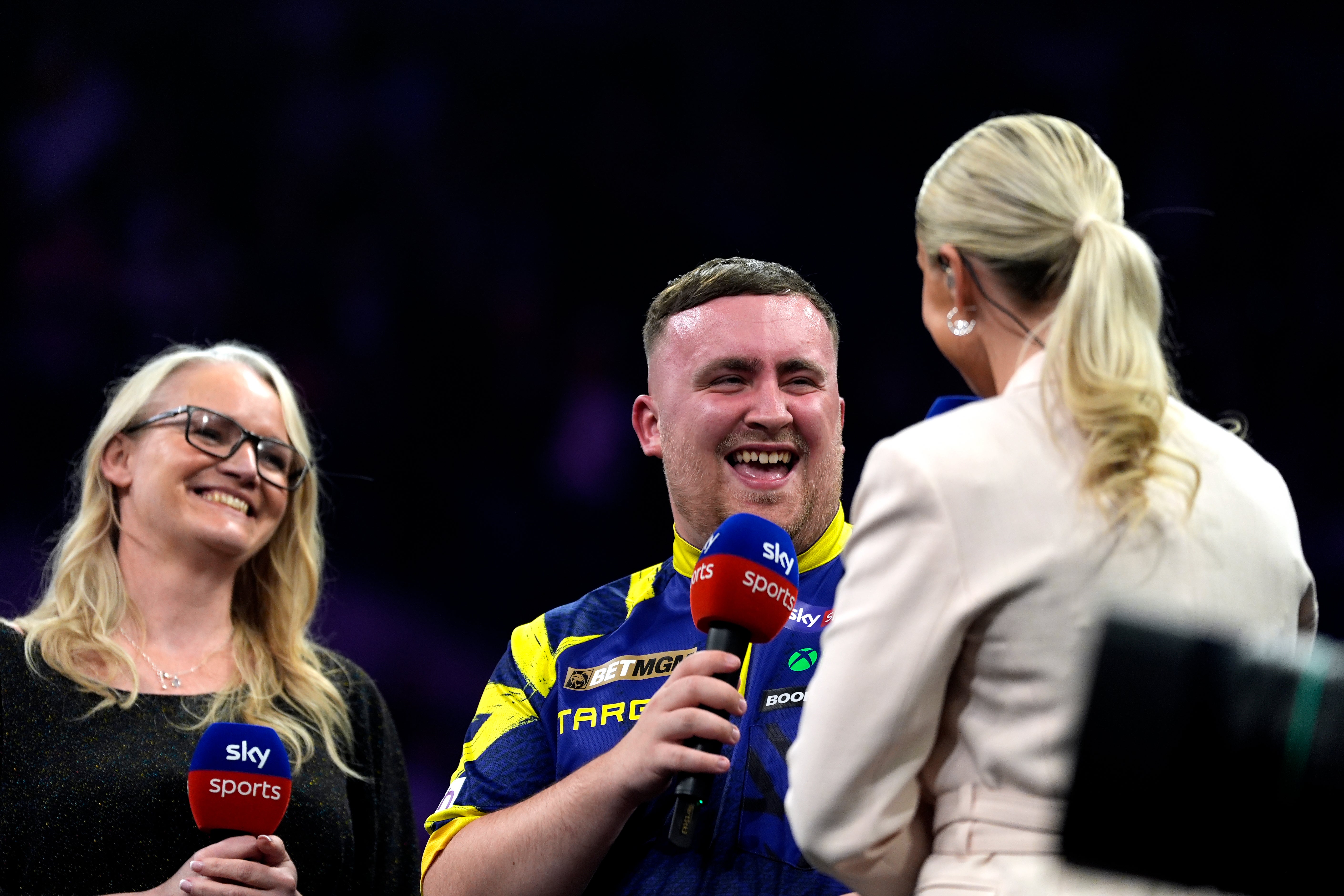 Luke Littler (centre) is interviewed after winning the final against Jonny Clayton on night twelve