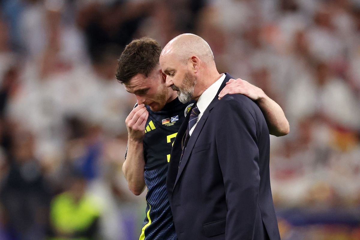 Andrew Robertson of Scotland embraces Stephen Clarke, Head Coach of Scotland, after defeat to Germany during the UEFA EURO 2024 group stage match between Germany and Scotland at Munich Football Arena 