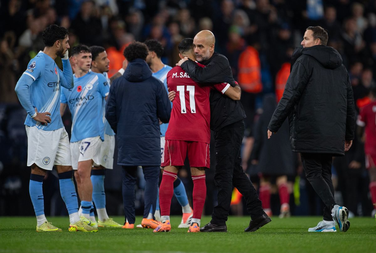 Man City manager Pep Guardiola embraces Liverpool forward Mohamed Salah.