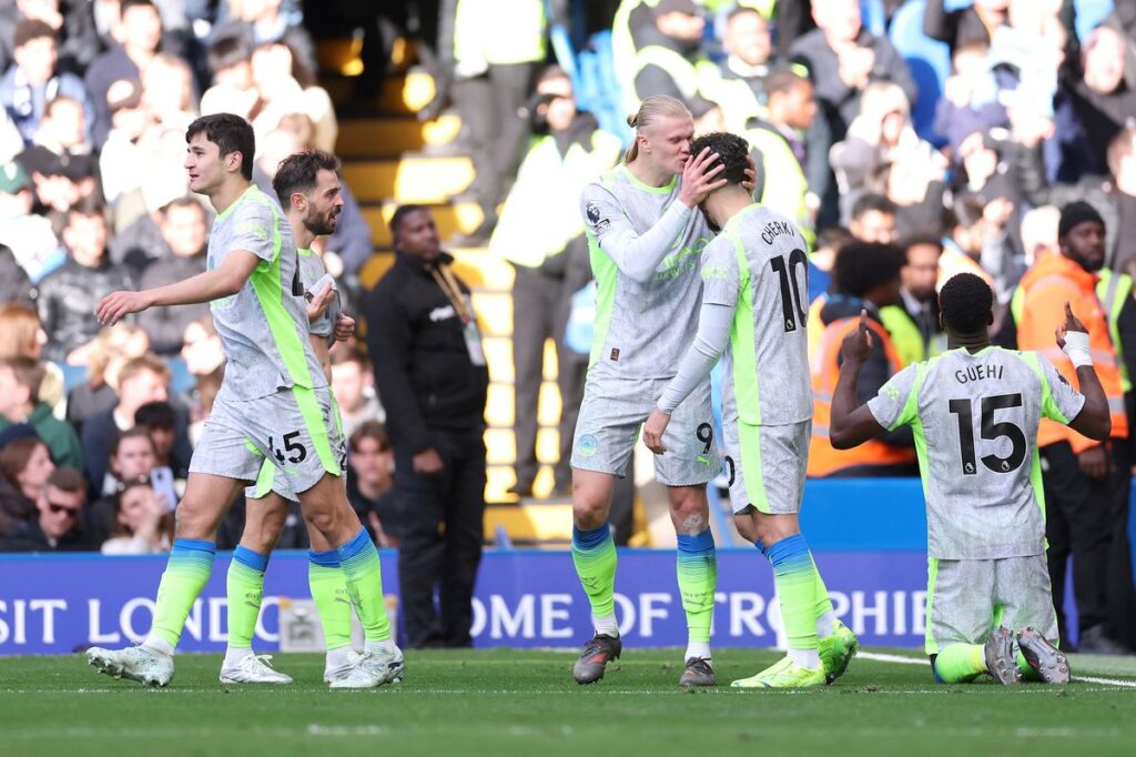 Marc Guehi of Manchester City celebrates scoring his team's second goal alongside Erling Haaland and Rayan Cherki during the Premier League match between Chelsea and Manchester City