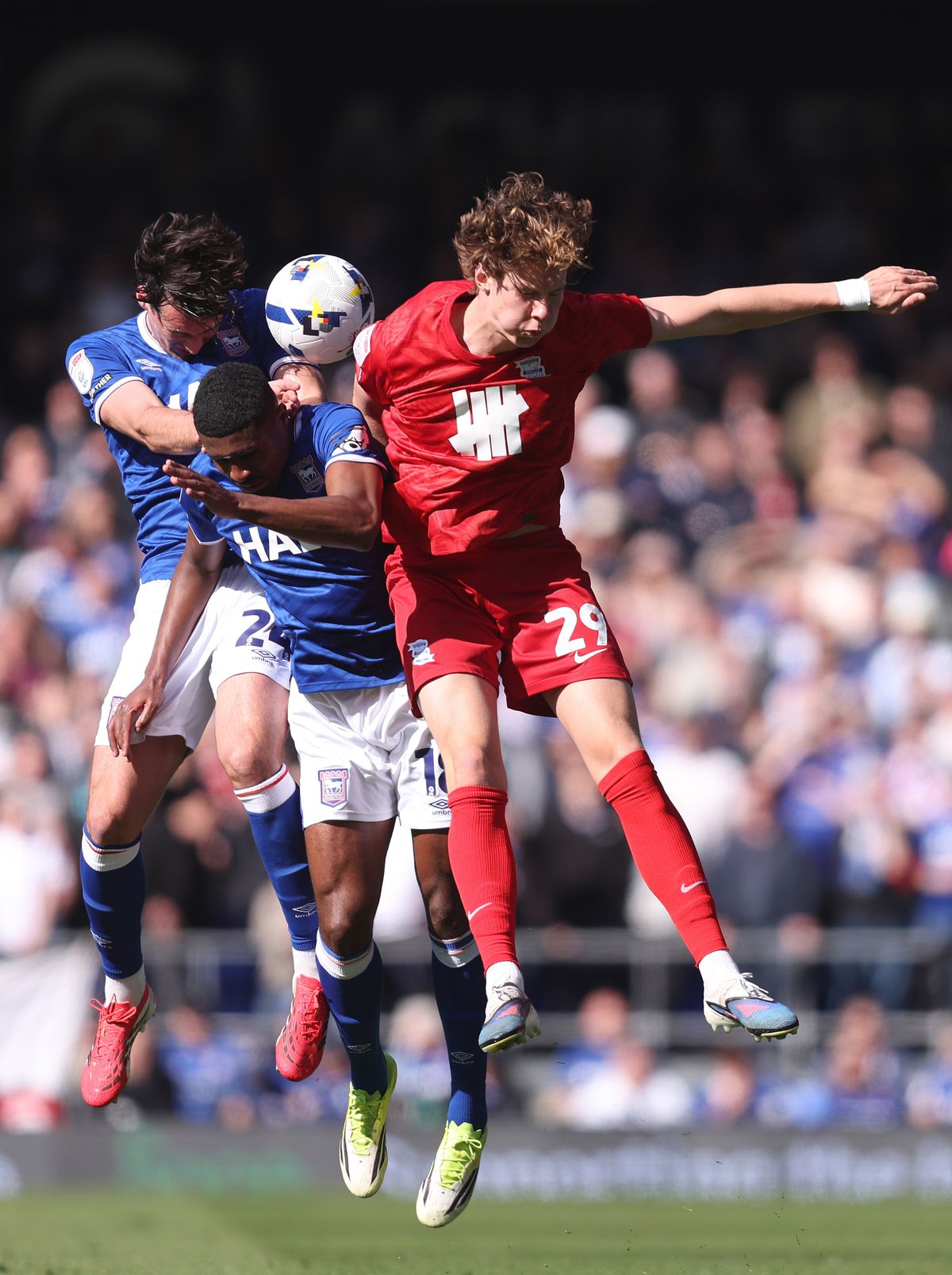 Jacob Greaves and Ben Johnson of Ipswich Town jump for the ball with August Priske of Birmingham City