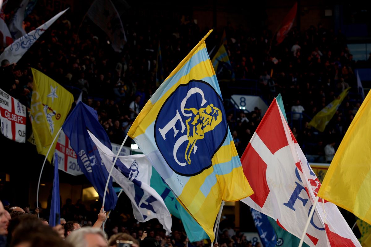 Fans wave flags prior to the Premier League match between Chelsea and Manchester United at Stamford Bridge