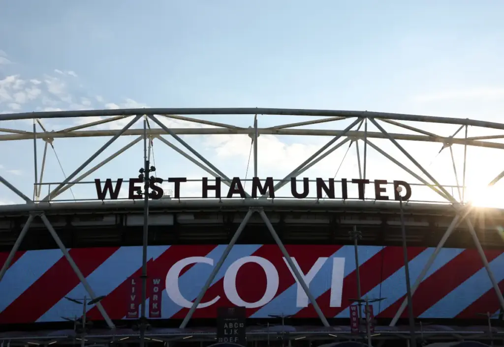 West Ham United's London Stadium seen as the sun sets, with the club's name sign on the top of the stand