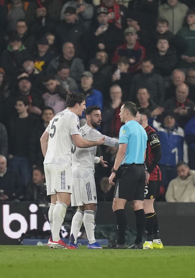 Manchester United’s Harry Maguire, left, and Bruno Fernandes speak with referee Stuart Attwell after Maguire's red card at Bournemouth