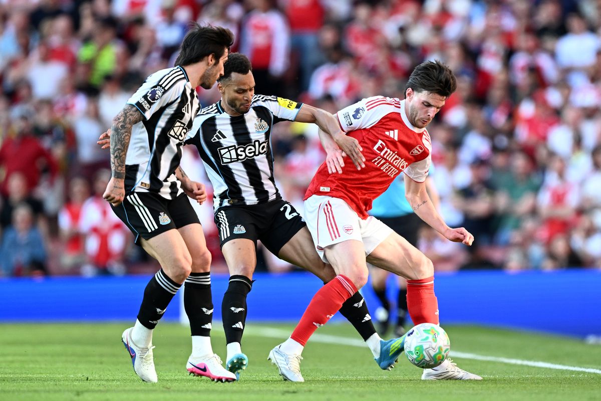 Declan Rice of Arsenal is challenged by Jacob Murphy and Sandro Tonali of Newcastle United