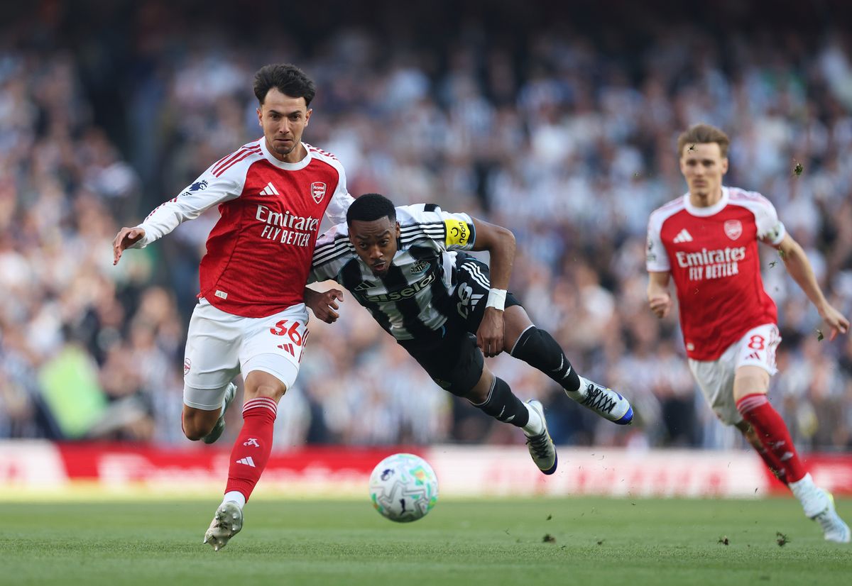 Joe Willock of Newcastle United is challenged by Martin Zubimendi of Arsenal 