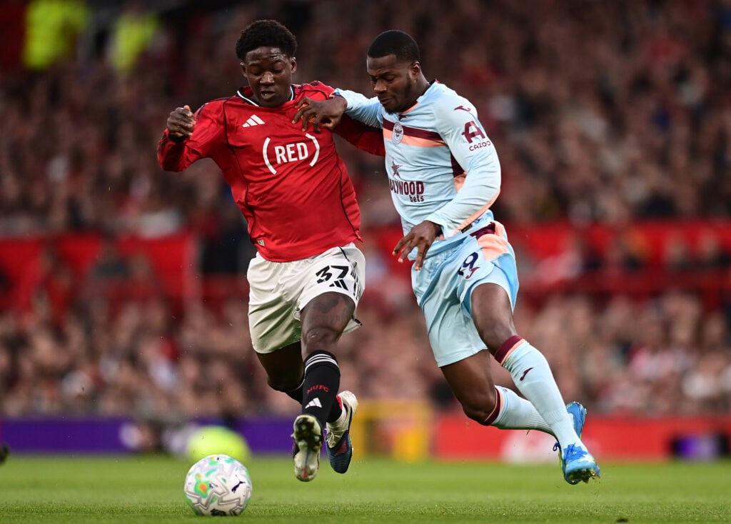Kobbie Mainoo competes with Dango Ouattara during the Premier League match between Manchester United and Brentford at Old Trafford in 2026 in Manchester, England.