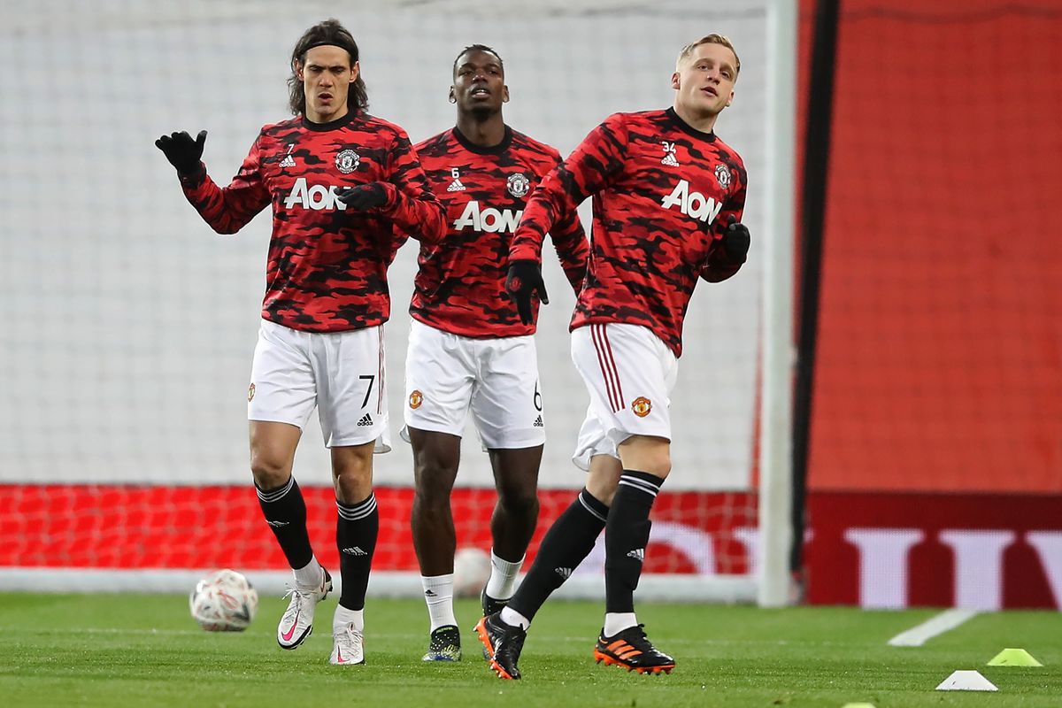 Manchester United's Uruguayan striker Edinson Cavani (L), Manchester United's French midfielder Paul Pogba (C) and Manchester United's Dutch midfielder Donny van de Beek (R) warm up ahead of the English FA Cup fourth round football match between Manchester United and Liverpool at Old Trafford