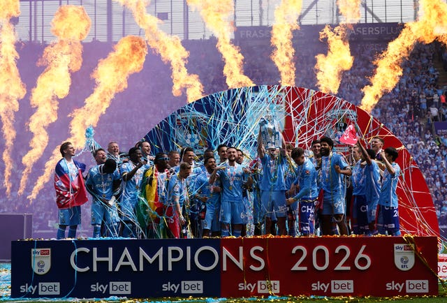 Coventry players lift the Championship trophy against a backdrop of streamers and fireworks