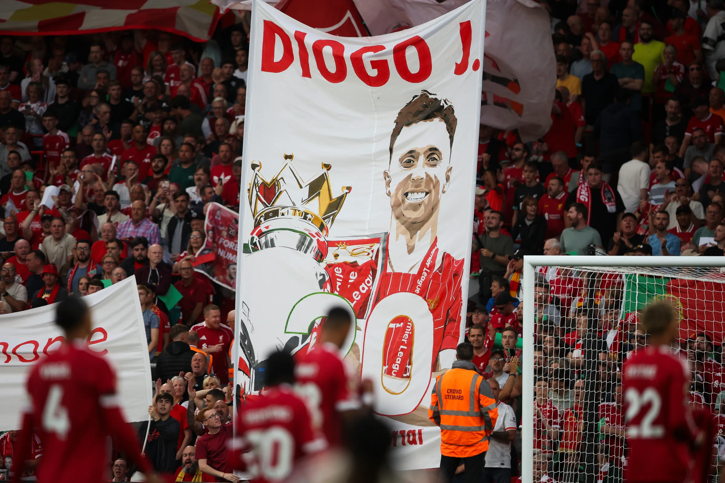 Liverpool fans hold a banner in tribute to Diogo Jota.