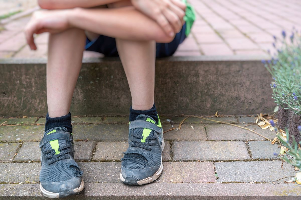 Photo of a child with damaged shoes