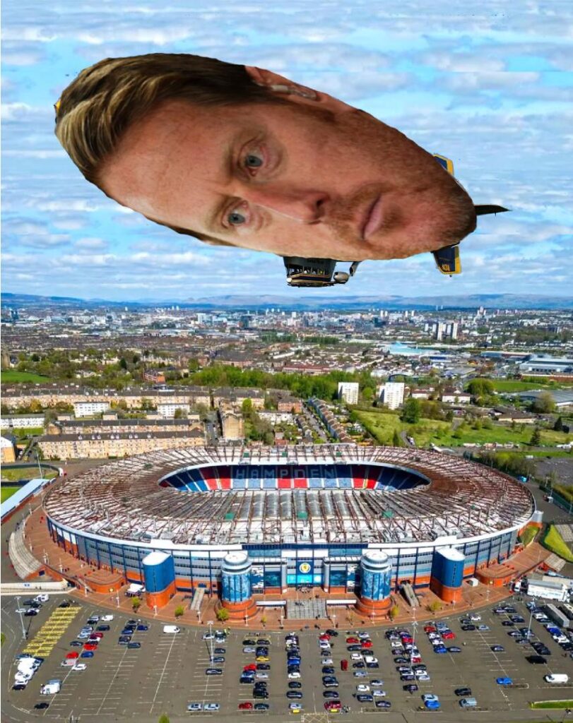 Live scenes as Michael Stewart pilots a blimp of his own face over Hampden Park. Always a professional.