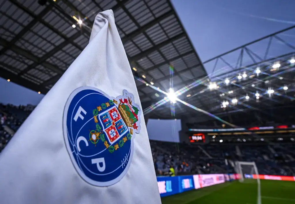 An FC Porto corner flag is seen in front of the Estadio do Dragao with the floodlights on