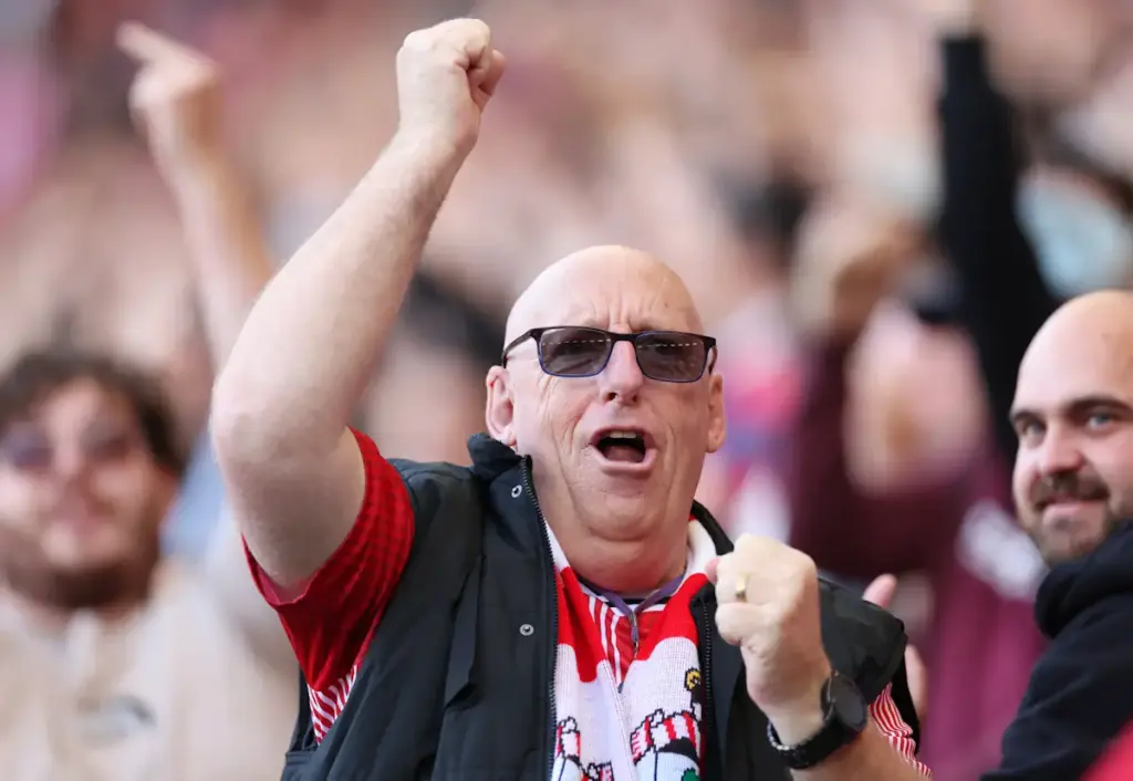 A Southampton fan celebrates a goal by waving his fist in the air