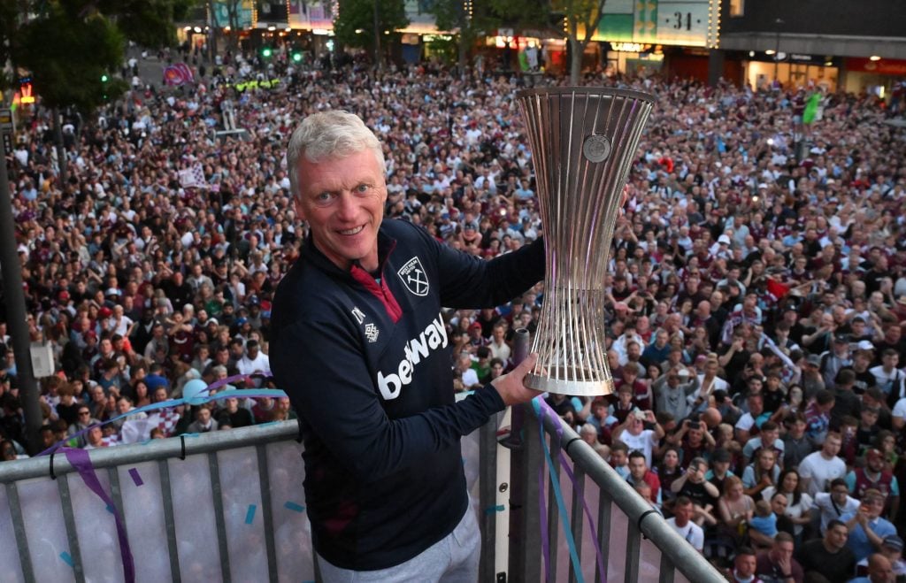David Moyes holds the Europa Conference League trophy aloft at the town hall after West Ham's open top bus parade through east London