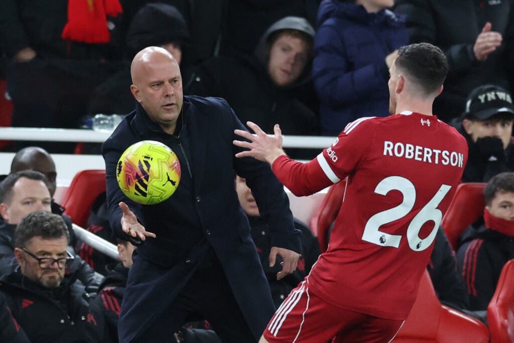 Arne Slot throws the ball to Andy Robertson during the English Premier League football match between Liverpool and Leeds United