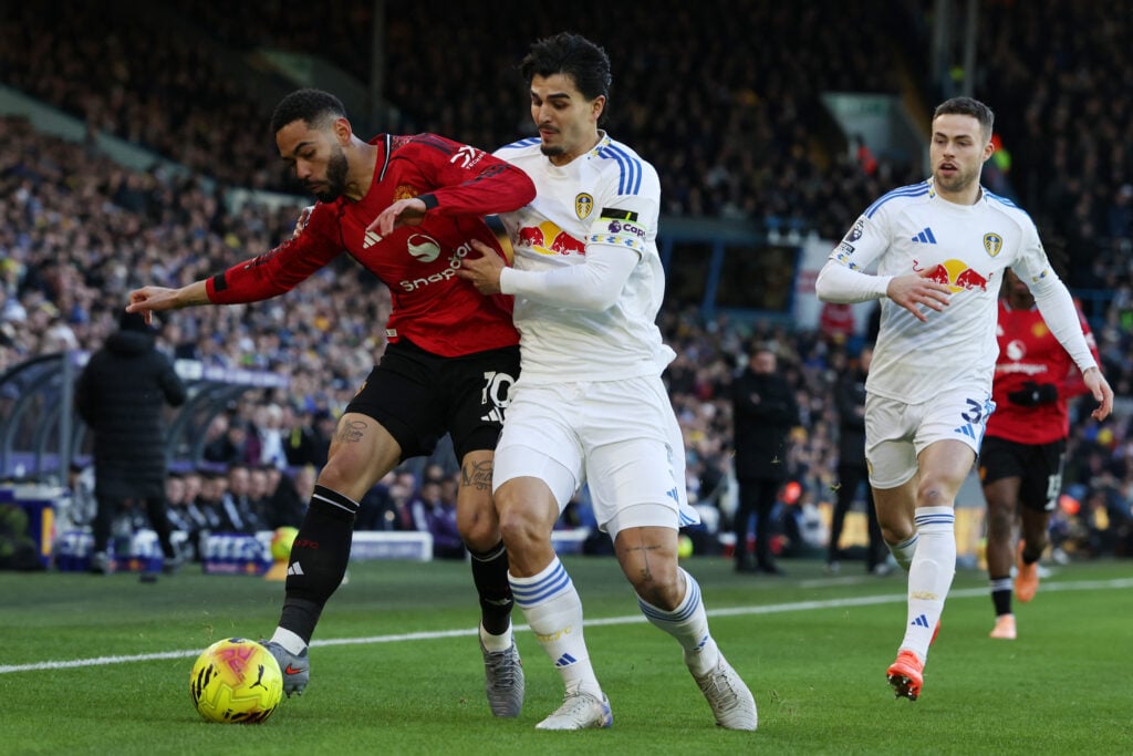 Matheus Cunha tries to hold off Pascal Struijk during the Premier League match between Leeds United and Manchester United at Elland Road in Leeds, England, in 2026.