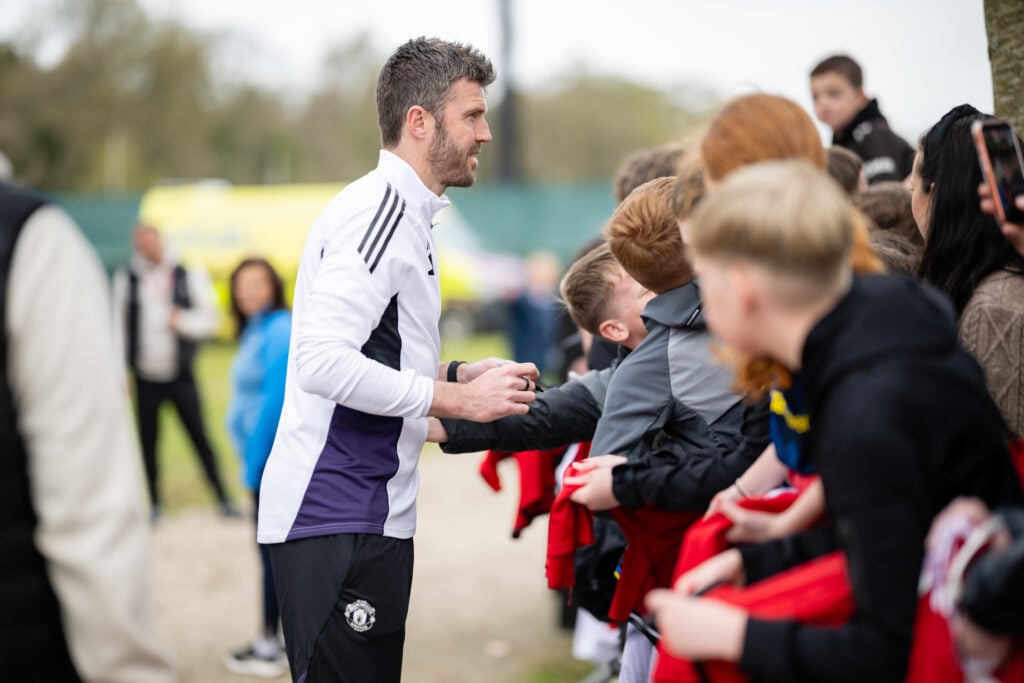 Michael Carrick signs autographs for fans after a first-team Manchester United training session in 2026 in Dublin, Ireland.