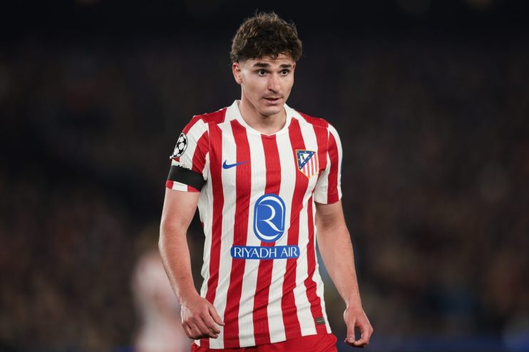 Business meeting with diverse professionals discussing strategy around a conference table in a modern office setting.