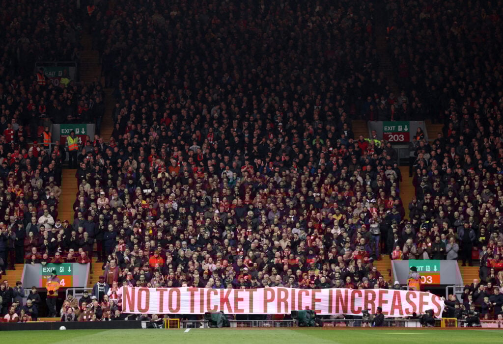 Fans of Liverpool display a banner in protest to the raising prices prior to the Premier League match between Liverpool and Fulham at Anfield on April 11, 2026 in Liverpool, England.
