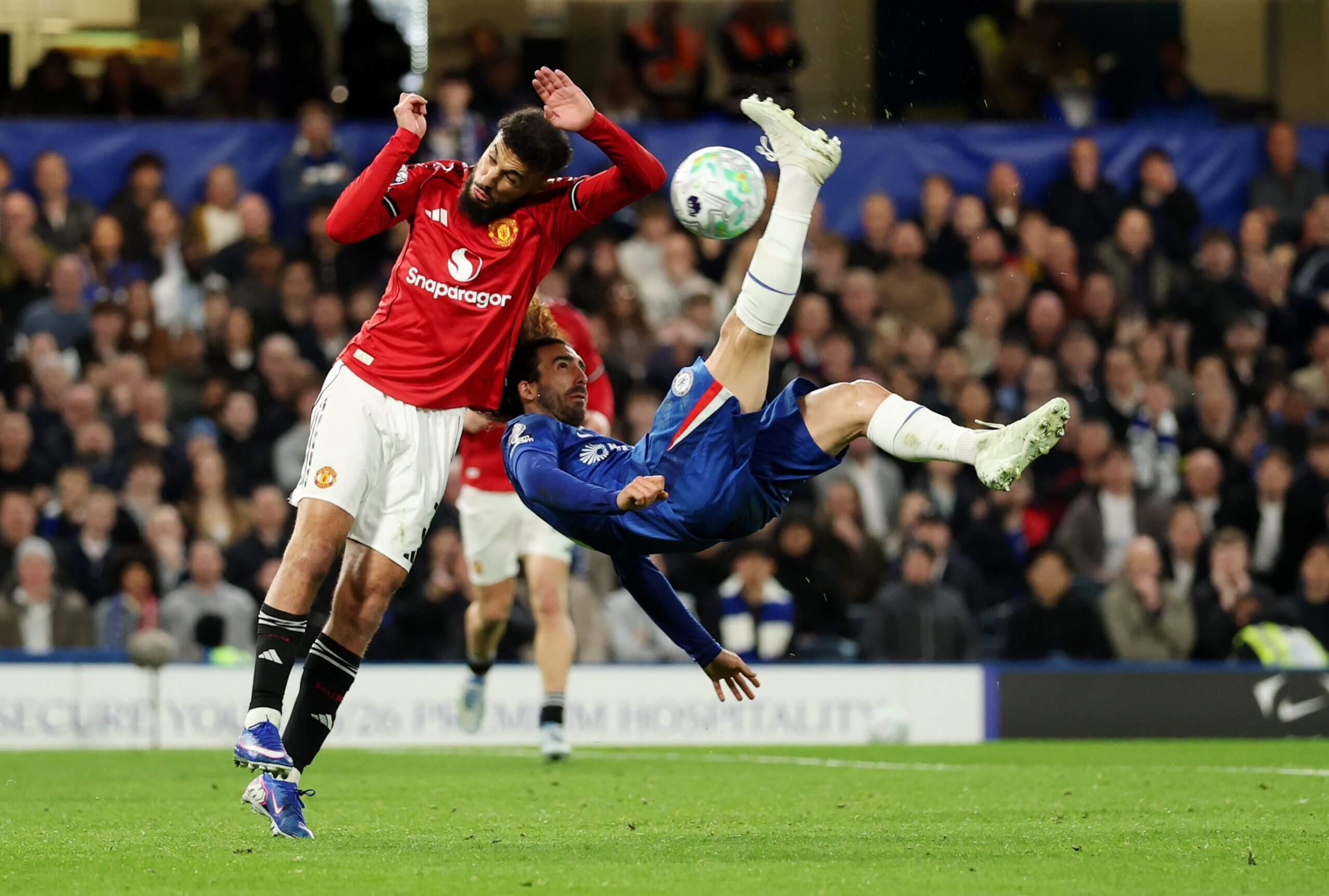 Manchester United's Noussair Mazraoui jumps to challenge Marc Cucurella as the Chelsea man attempts an overhead kick