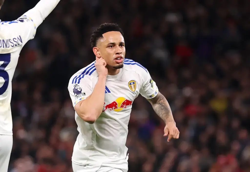 Noah Okafor cups his ears and runs away to celebrate scoring for Leeds United