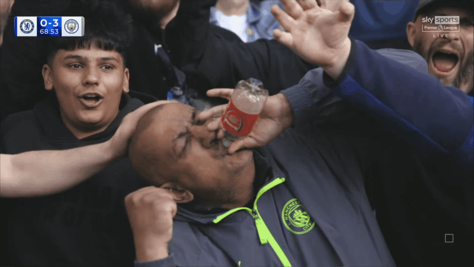 Manchester City fan celebrates with an Arsenal bottle