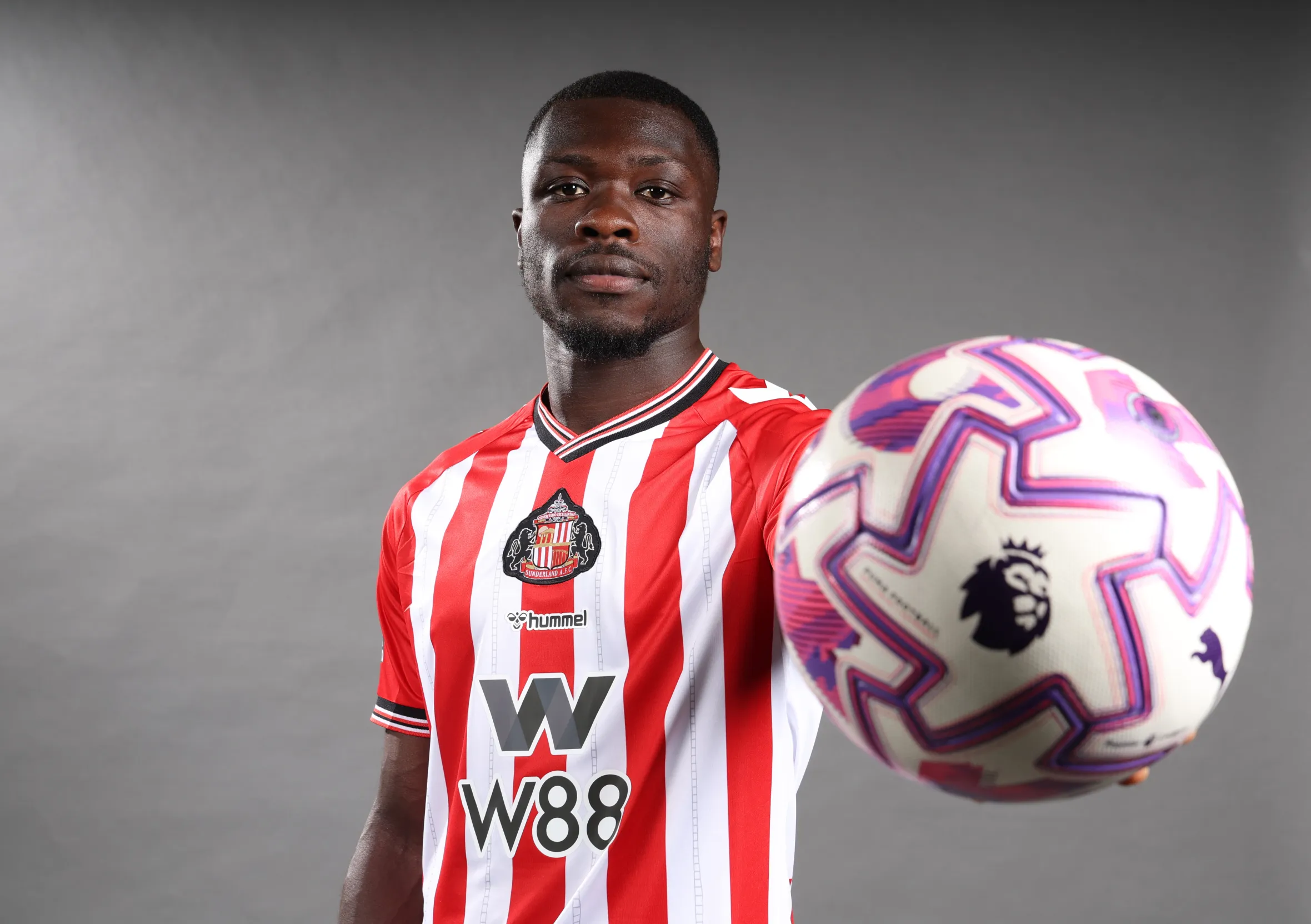 Sunderland AFC new signing Brian Brobbey posing for pictures with a soccer ball.