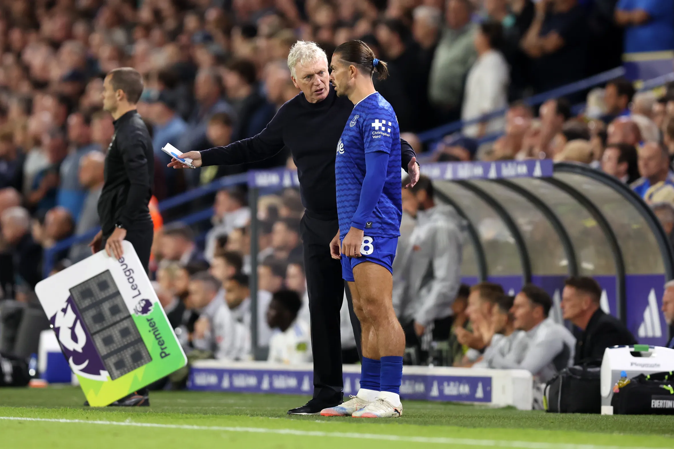 David Moyes, Everton Manager, speaks with Jack Grealish on the sideline during a Premier League match.