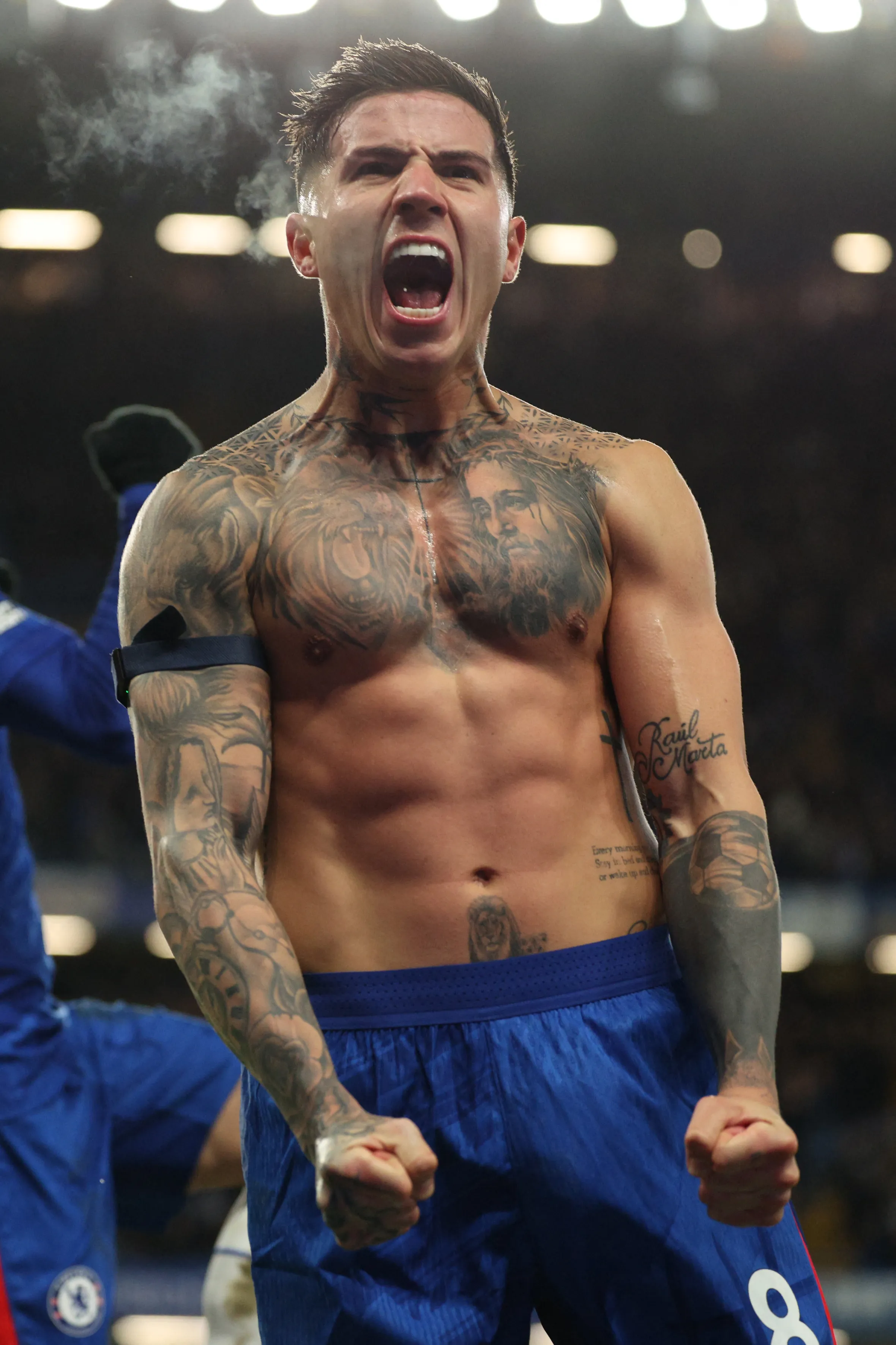 Chelsea's Argentinian midfielder Enzo Fernandez celebrates a goal with his shirt off, revealing chest and arm tattoos.