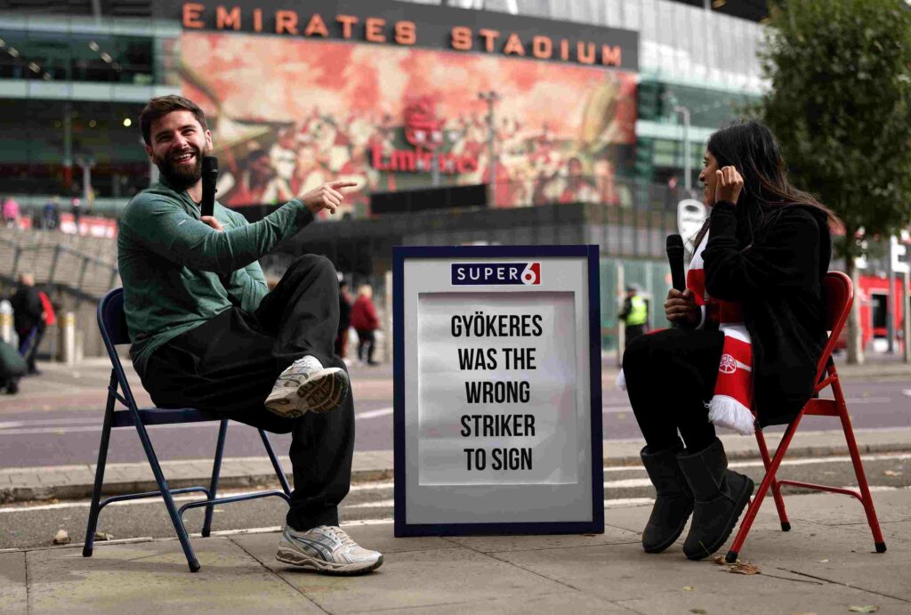 LONDON, ENGLAND - OCTOBER 04: Fans are interviewed by Sky Sports next to a sign reading 