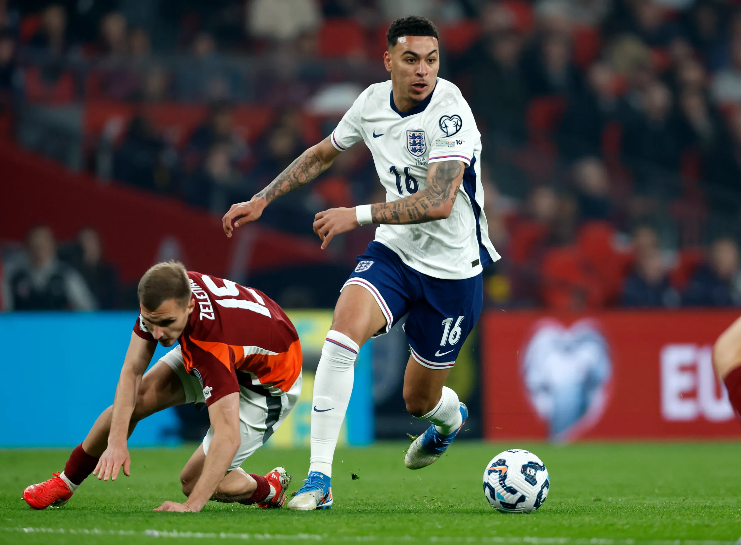 Morgan Rogers of England dribbles away from Dmitrijs Zelenkovs of Latvia.