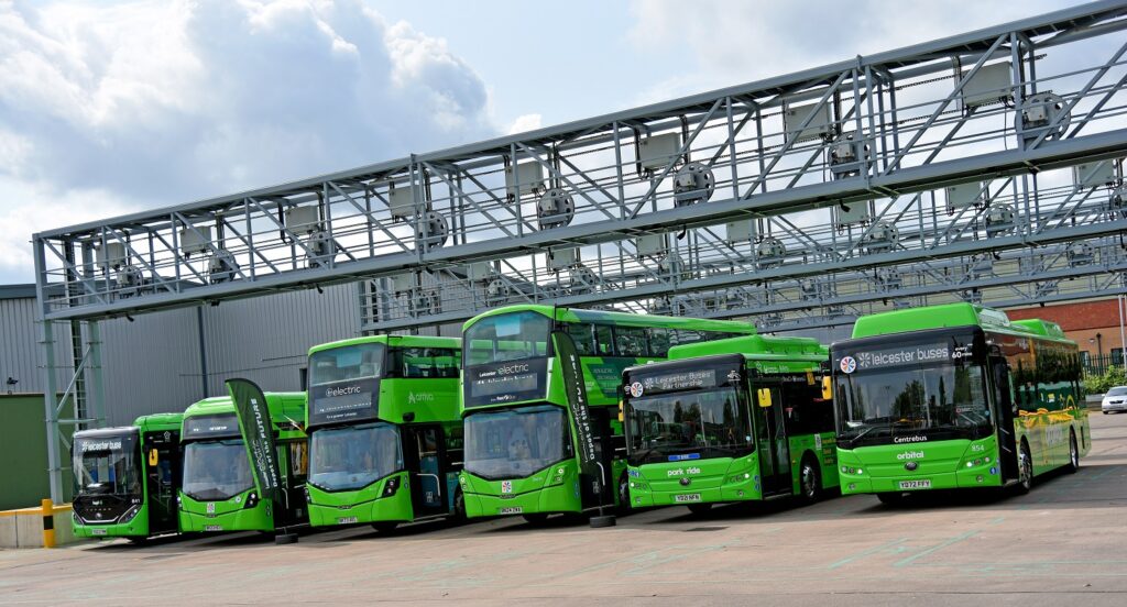 Green electric buses in a line.