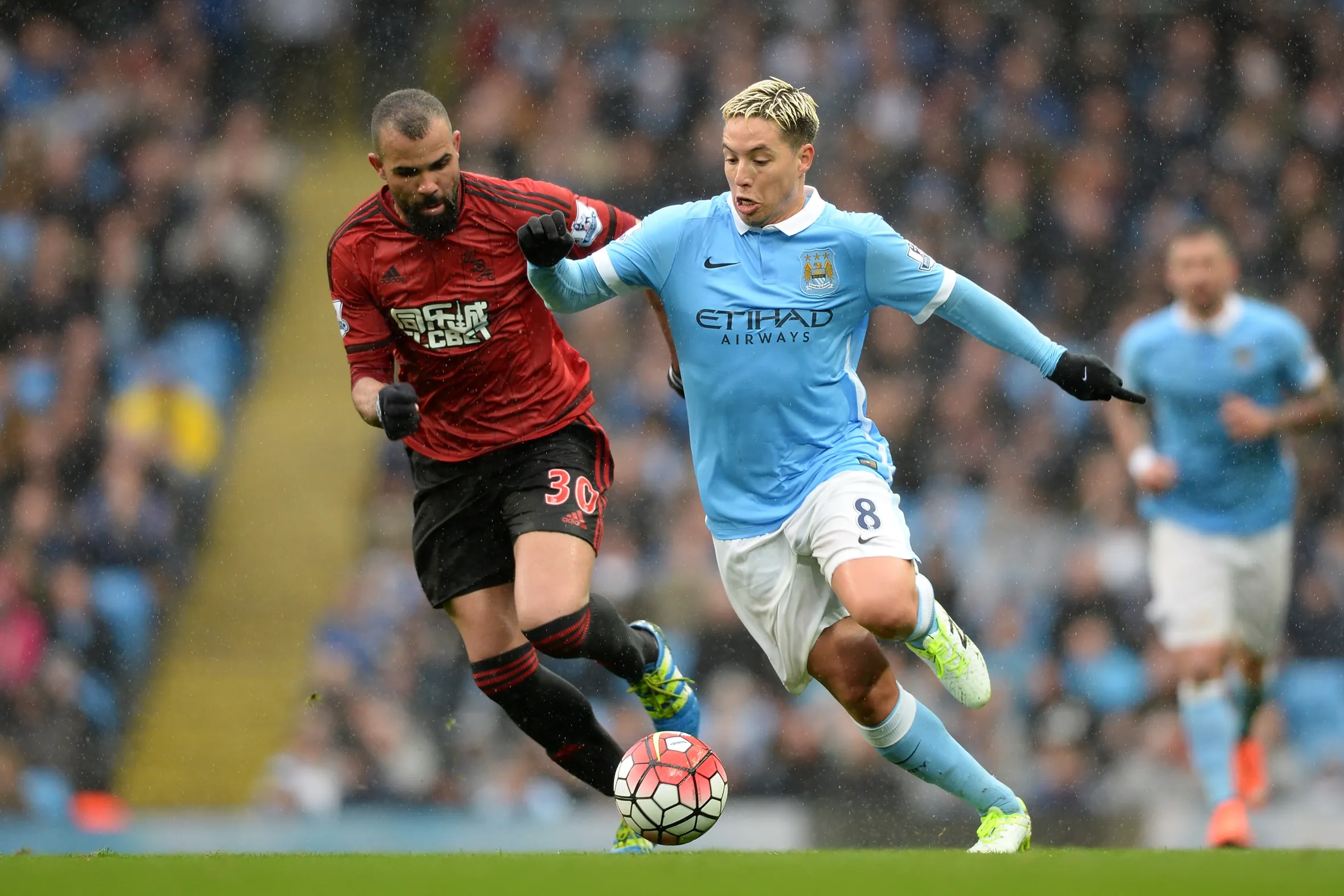 Samir Nasri of Manchester City and Sandro of West Bromwich Albion compete for the ball.