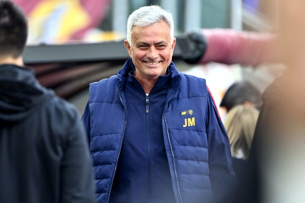 Jose Mourinho smiling on the touchline.