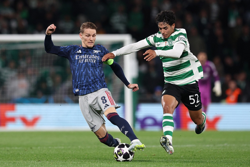 Martin Odegaard of Arsenal is challenged by Joao Simoes of Sporting Clube de Portugal during the UEFA Champions League 2025/26 Quarter-Final First Leg match between Sporting Clube de Portugal and Arsenal FC at Estadio Jose Alvalade on April 07, 2026 in Lisbon, Portugal. (Photo by Carlos Rodrigues/Getty Images)