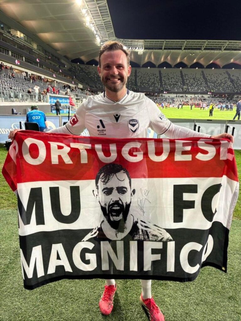 Juan Mata holding a Bruno Fernandes flag after Melbourne Victory's 2-0 win at Western Sydney Wanderers last night