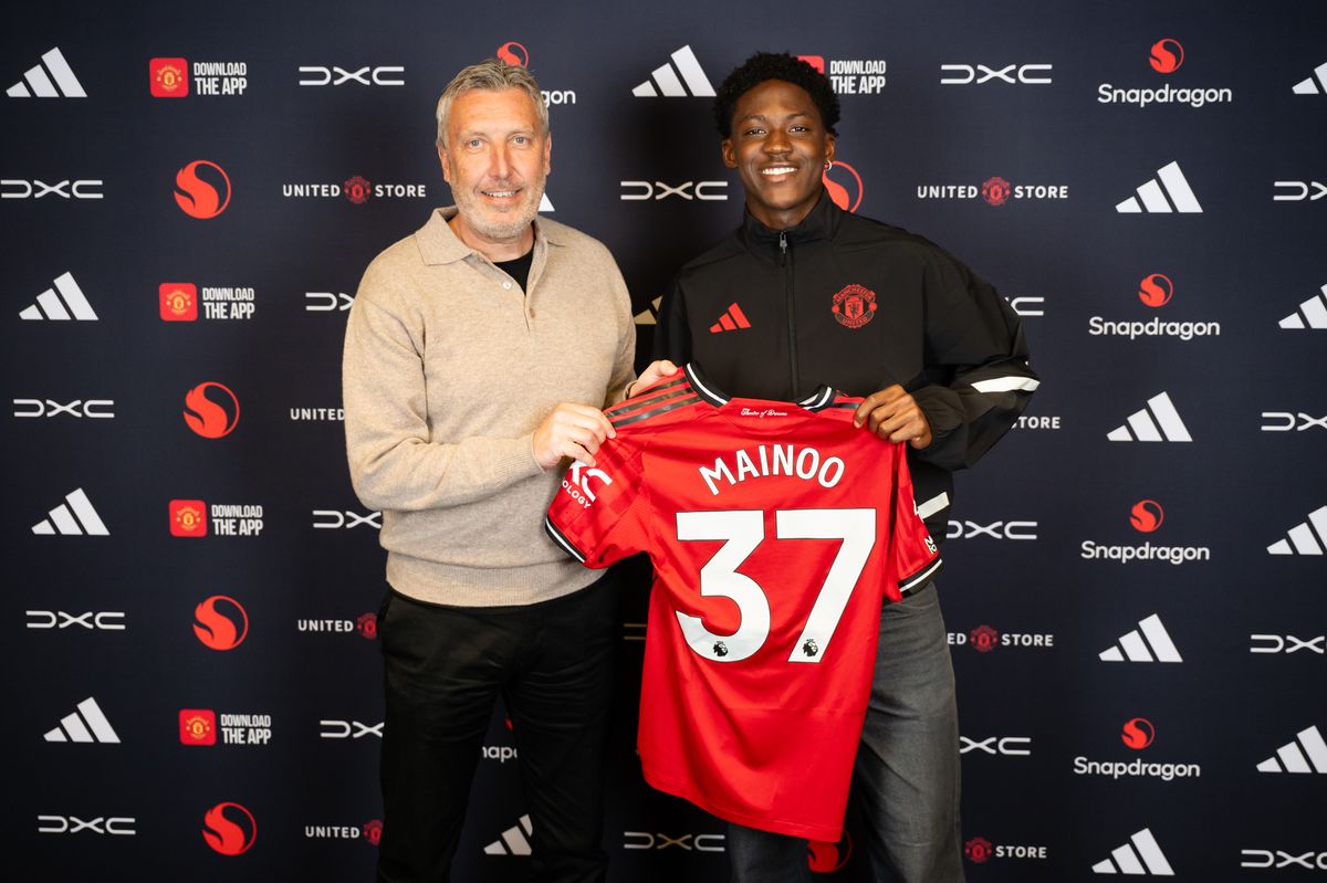Kobbie Mainoo of Manchester United poses with Director of Football Jason Wilcox after signing a new contract at the club at Carrington Training Ground on April 30, 2026 in Manchester, England.