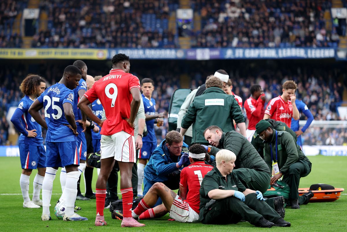 Morgan Gibbs-White of Nottingham Forest receives medical treatment following a clash with Robert Sanchez of Chelsea 
