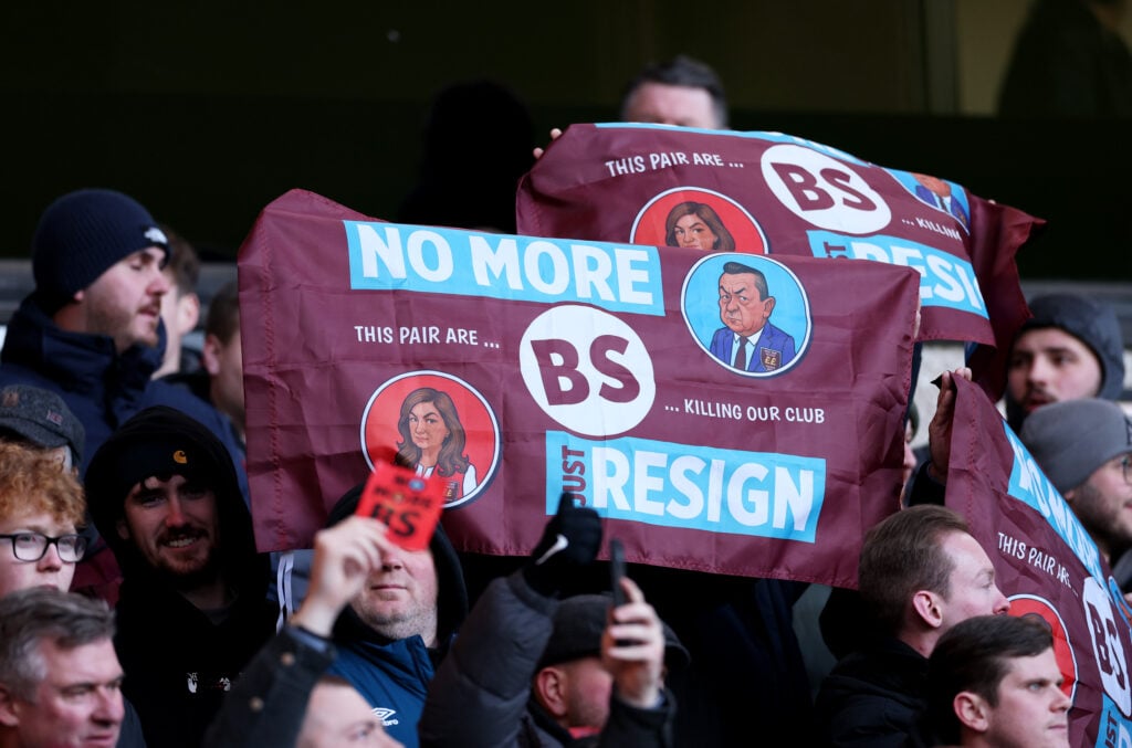 West Ham United fans hold up No More BS Just resign flags featuring caricatures of Karren Brady and David Sullivan as they protest against the ownership during the Premier League match between Wolverhampton Wanderers and West Ham United at Molineux on January 03, 2026 in Wolverhampton, England.